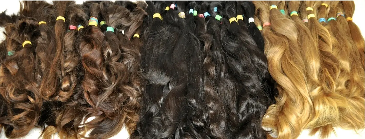 Bundles of unprocessed European human hair in brown, black, and blonde shades